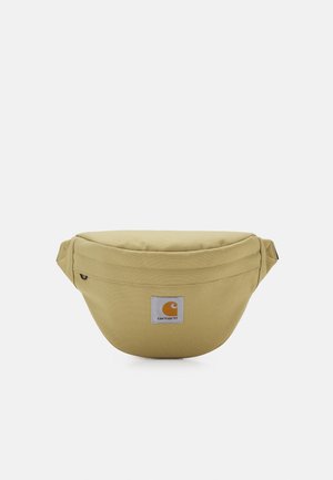 Beżowa torba na biodra Carhartt z przednią kieszenią na zamek i naszywką z logo na środku na białym tle.