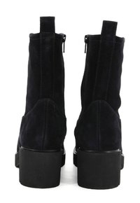 Stivaletti neri in suede fino alla caviglia con un tacco robusto e cerniere laterali, caratterizzati da una texture liscia e un design semplice e moderno.