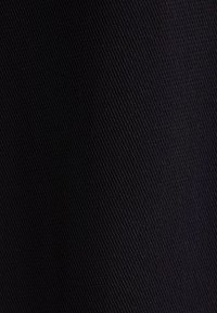 Czarny materiał teksturowany z wzorem siatki, o matowym wykończeniu i drobnym splocie, odpowiedni do różnych zastosowań.