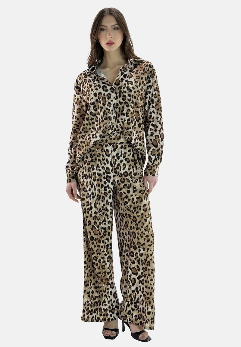 Set di pigiama in seta con stampa leopardata, composto da una camicia a maniche lunghe dal taglio rilassato e pantaloni a gamba larga, caratterizzato da una texture morbida e tonalità terrose.