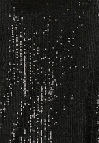 Tessuto nero ricoperto da una serie di paillettes argentate disposte in un motivo sparso, creando una superficie testurizzata e riflettente.