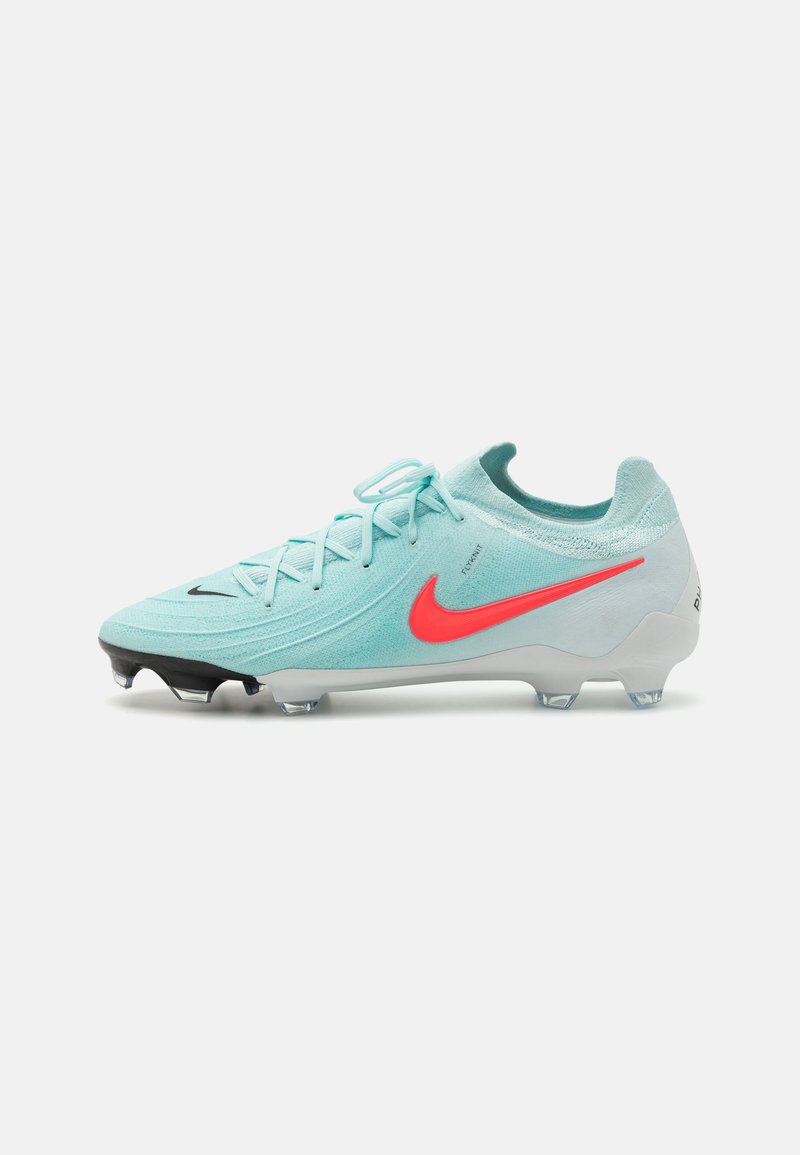 Svijetloplava nogometna kopačka s teksturiranim gornjim dijelom, crnim potplatom i hrabrom crvenom Nike logotipom. Ima elegantan dizajn i tradicionalno vezivanje.