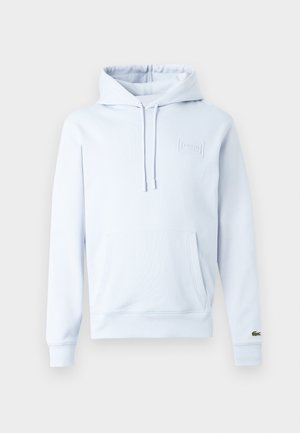 Hellblauer Hoodie aus weichem Stoff, mit Kängurutasche, verstellbaren Kordeln und einem geprägten Logo auf der Brust.