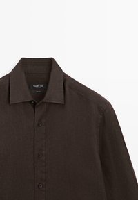 Dark brown long-sleeve linen shirt with collar and buttons down the front, shown from the shoulders up on a white background.