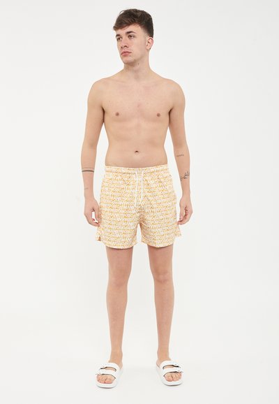 Costumi da bagno da uomo con un motivo ripetitivo in giallo e bianco. Progettati con una vita elasticizzata e tasche laterali, realizzati in tessuto leggero.