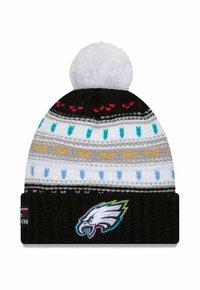 Strickmütze mit einem weißen Pompon, ausgestattet mit einem schwarzen Band mit gesticktem Adler-Logo und mehrfarbigen Musterrändern.