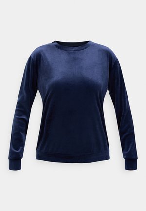 Donkerblauw fluwelen shirt met lange mouwen en een ronde hals, voorzien van nauwsluitende manchetten en een licht gebogen zoom, getoond op een effen lichtgrijze achtergrond.