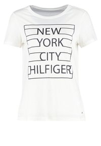 Biały t-shirt z krótkim rękawem, z czarnymi obrysowanymi prostokątami i napisem "NEW YORK CITY HILFIGER" na przodzie.