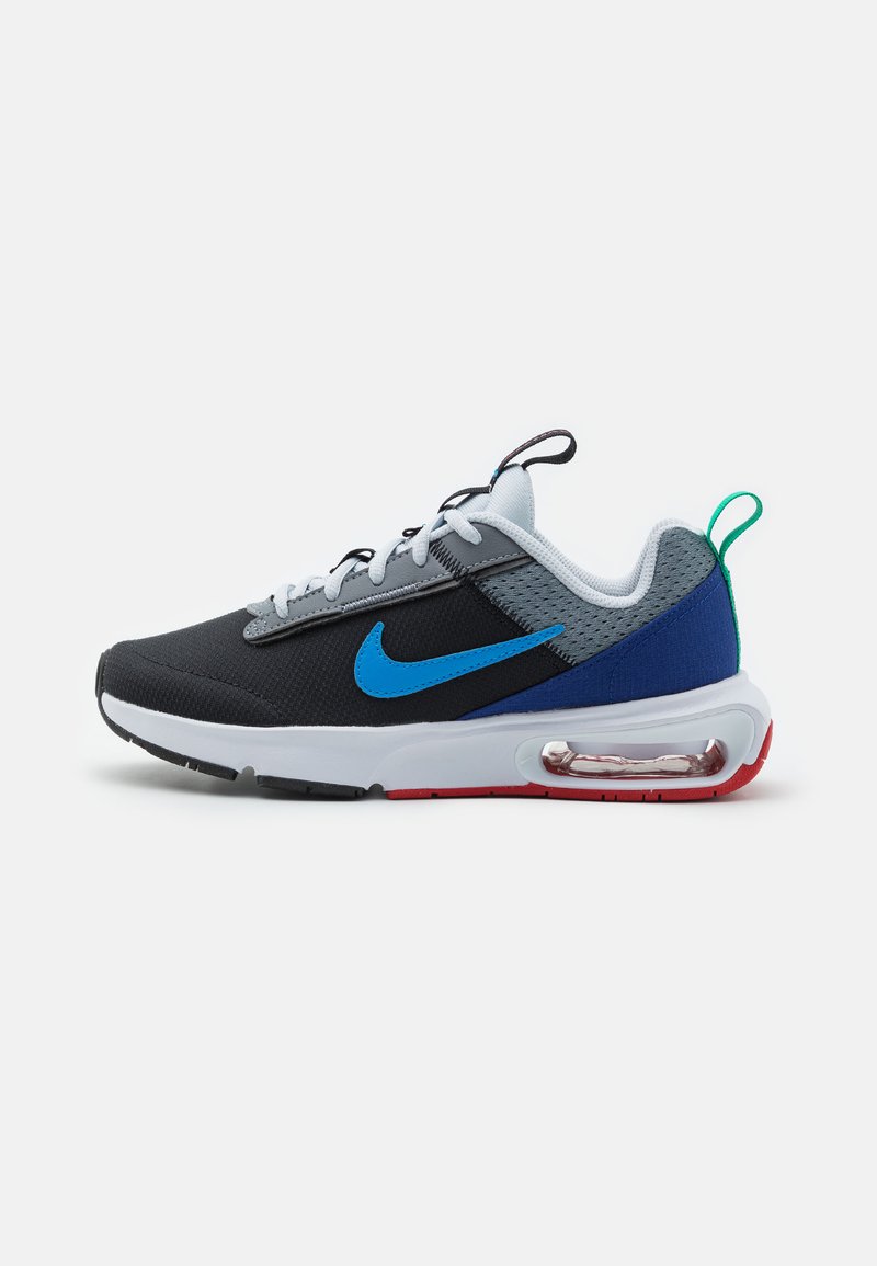 Nike tornacipő fekete hálós felsőrésszel, kék Swoosh-sal, szürke díszítésekkel és fehér talppal. Légpárnás párnázással és piros talppal, zöld sarokhurkolóval rendelkezik.