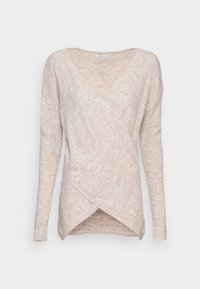 Pull en beige à style châle avec des manches longues, un décolleté en V et un tissu texturé. Notable devant croisé et poignets côtelés.