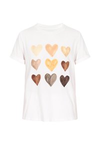 Hvid t-shirt med et mønster af hjerter i forskellige nuancer af beige og brunt. Korte ærmer, rund hals, lavet af bomuldsstof.