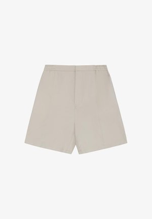 Bež krojene kratke hlače s elastičnim strukom i detaljima šavova sprijeda, prikazane ravno na bijeloj pozadini.