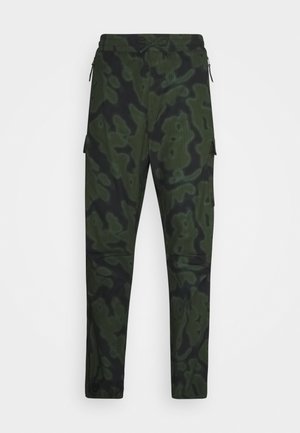 Cargo pants in dark green with a black abstract camouflage pattern. Features include a drawstring waist and side pockets. Made from textured fabric.