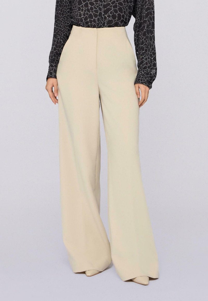 Creme kleurige wijde broek gemaakt van zachte stof met een gladde textuur, met een hoge taille en een minimalistisch ontwerp.