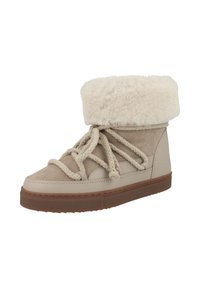 Botín de tobillo beige con un puño de piel sintética, parte superior de ante y suela de goma. Presenta cordones gruesos de cuerda y un diseño de punta redonda.