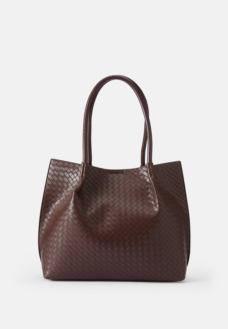 Bolso tote de cuero trenzado marrón con dos asas, que presenta una superficie texturizada y un diseño de abertura superior. Forma minimalista sin hardware adicional.
