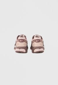 Αθλητικά παπούτσια με επάνω μέρος από δίχτυ και συνθετικό υλικό, κυρίως σε ανοιχτό ροζ και καφέ αποχρώσεις, με υφασμένα στοιχεία και επενδυμένες σόλες.