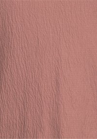 Tejido texturizado en un tono rosa apagado, con un patrón ondulado y un ligero brillo, con pliegues visibles por toda la superficie.