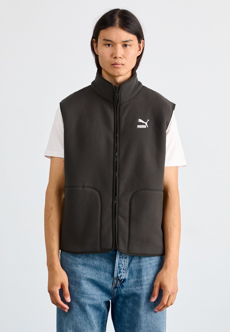 Dunkelgraue Fleece-Weste mit hohem Kragen, Frontreißverschluss und zwei großen Seitentaschen. Mit einem weißen Puma-Logo auf der linken Brust.