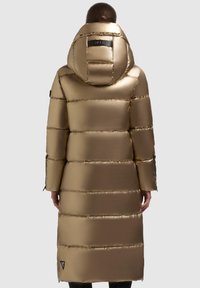 Gouden pufferjas met een capuchon, featuring een glanzend, gewatteerd ontwerp, lange lengte en een zwart logo detail op de achterkant. Ritsmanchetten.