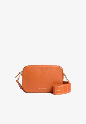 Sac bandoulière en cuir orange texturé avec sangle large en tissu détachable et ferrures dorées, nom de la marque centré sur le devant.
