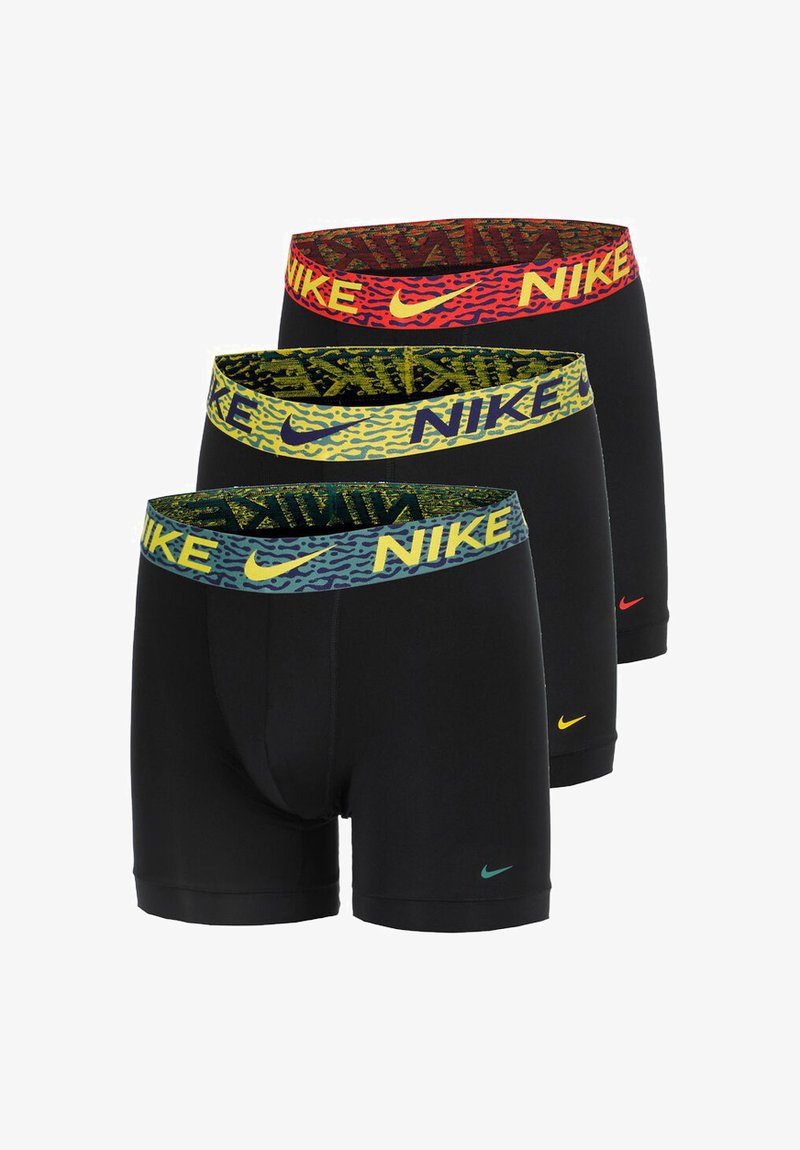 Tre par med svarte boxershorts med fargerike merkevare-beltelinninger. Beltelinningene har blå, gule og røde mønstre med 'NIKE'-logo.