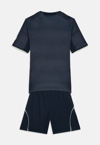 Σκούρο μπλε αθλητικό σετ που περιλαμβάνει ένα ριγέ μπλουζάκι με κοντό μανίκι και αντίστοιχα σορτς. Διακοσμημένο με ανοιχτό πράσινο ραφές κατά μήκος των πλαινών των σορτς.