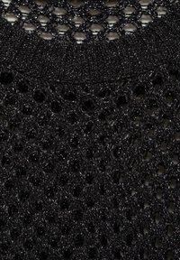 Top nero lavorato a maglia con un design a rete decorato. La texture è lucida con una tessitura ampia e un colletto a girocollo a coste.