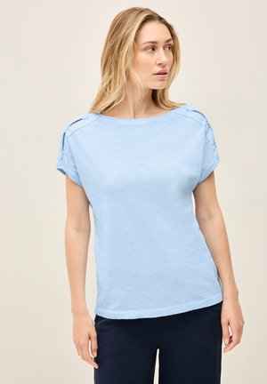Haut à manches courtes bleu clair fabriqué en tissu doux, avec un col large et une couture décorative sur les épaules. Complété par une coupe décontractée.