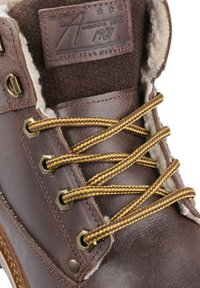 Stivale in pelle marrone, con lacci intrecciati oro e marrone, occhielli metallici e foderato in lana. Il tacco presenta un particolare a contrasto con texture.