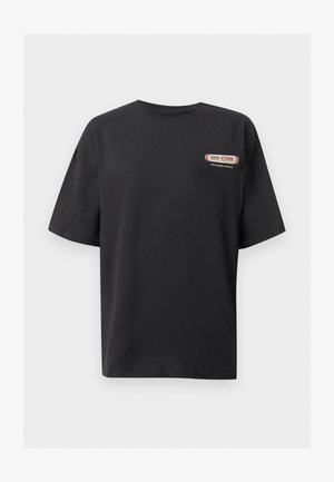 T-shirt noir à manches courtes avec petit logo et texte "RIP CURL" rouge et blanc sur la partie supérieure gauche de la poitrine.