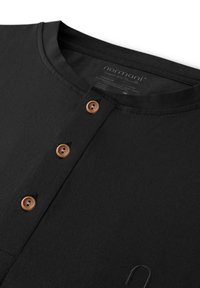 Schwarzes Langarmshirt mit rundem Ausschnitt, ausgestattet mit fünf Holzknöpfen, dezent gerippter Textur und einem aufgestickten Logo auf der Vorderseite.