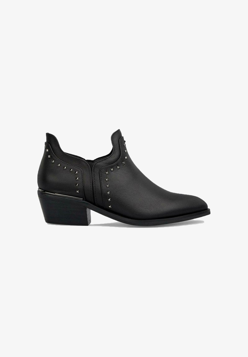 Bottines noires avec un bout pointu, en cuir lisse, dotées de clous en métal sur les côtés et d'un petit talon carré.