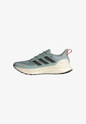 Jasnozielone buty do biegania z czarnymi paskami, teksturowana cholewka, biała podeszwa środkowa z pomarańczowymi plamkami i czarna gumowa podeszwa.