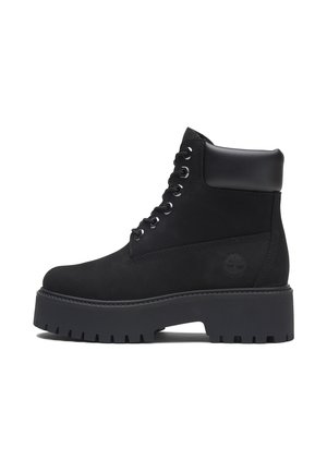 Bottine noire à lacets avec semelle épaisse à crampons et col rembourré, logo latéral embossé sur dessus en cuir mat.