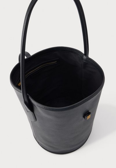 Μαύρη δερμάτινη τσάντα τύπου bucket με μία λαβή, στρογγυλή βάση και εσωτερική τσέπη με φερμουάρ και χρυσό τράβηγμα φερμουάρ.