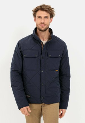 Navy quilted jacket with a stand collar, two chest pockets, and button closures. Features brown accents and a textured finish.