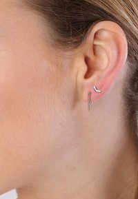 Zilveren geometrische stud oorbellen in verschillende vormen, met een strakke, minimalistische uitstraling met scherpe hoeken en een gladde textuur.