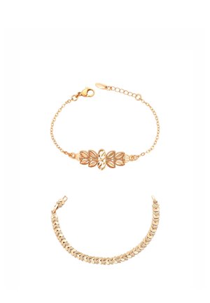 Dwie bransoletki w złotym kolorze na białym tle, jedna z motywami liści i zapięciem łańcuszkowym, druga z połączonymi segmentami w wzór jodełki.