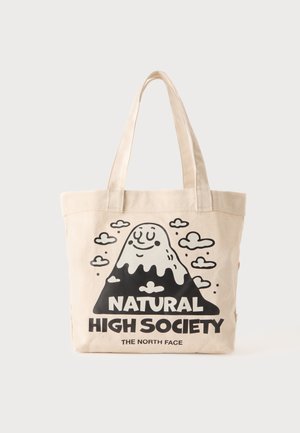 Sac fourre-tout beige avec de longues anses, avec une illustration d'une montagne souriante, des nuages et le texte "Natural High Society The North Face."