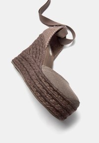 Espadrillas a zeppa marroni con suola in juta intrecciata testurizzata e parte superiore in tessuto. Presentano lacci alla caviglia e un design con punta arrotondata.