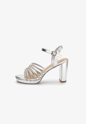 Sandalo con tacco argento caratterizzato da un design a fascia larga con finitura metallica e dettagli in strass, un tacco a blocco robusto e una cinghia regolabile alla caviglia.