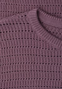 Gros plan d'un pull tricoté violet montrant un col en côtes et un motif de point texturé avec des rangées alternées de maille pleine et ajourée.