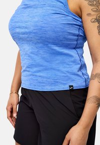 Zils sporta bezpalīga ar horizontālu faktūru, apaļu kakla izgriezumu un kontrastējošām šuvēm, apvienota ar melniem šortiem ar kabatām.