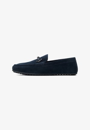 Navy blue suede loafers with a stitched design, rounded toe, and a decorative metallic accent at the top. Textured rubber outsole.