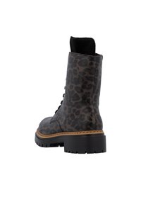 Bottines à imprimé léopard en cuir lisse avec un bout arrondi, un laçage sur le devant et une semelle en caoutchouc noir épaisse.