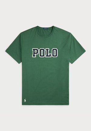 Green cotton t-shirt featuring a large "POLO" logo in white and navy blue. Short sleeves, crew neck, and small logo detail at the hem.