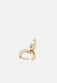 Boucles d'oreilles créoles en doré avec une fermeture circulaire à charnière. Présente une finition polie et un détail de marque gravé sur le devant.