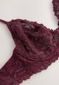 Brusnicová čipkovaná podprsenka s prepracovanými kvetinovými vzormi, vlnkovanými okrajmi a textúrovaným dizajnom. Nastaviteľné ramienka v zodpovedajúcej farbe.