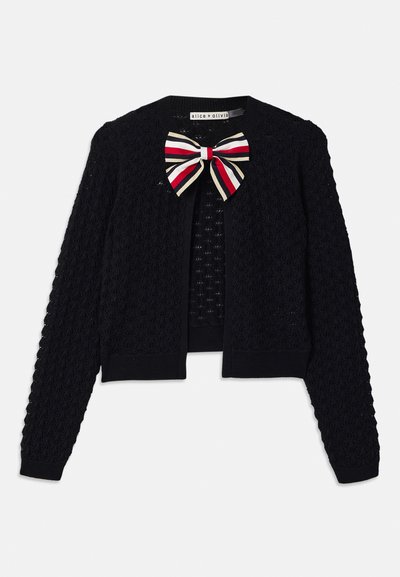 Čierny háčkovaný cardigan s dlhými rukávmi a veľkou červenou, bielou a béžovou pruhovanou mašľou na výstrihu, štítok znie "alice + olivia."